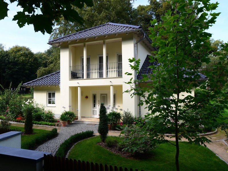 Diese Villa steht mitten in einem großzügigen Park und passt sich hervorragend der Umgebung an. Der Säuleneingang prägt das Entree.